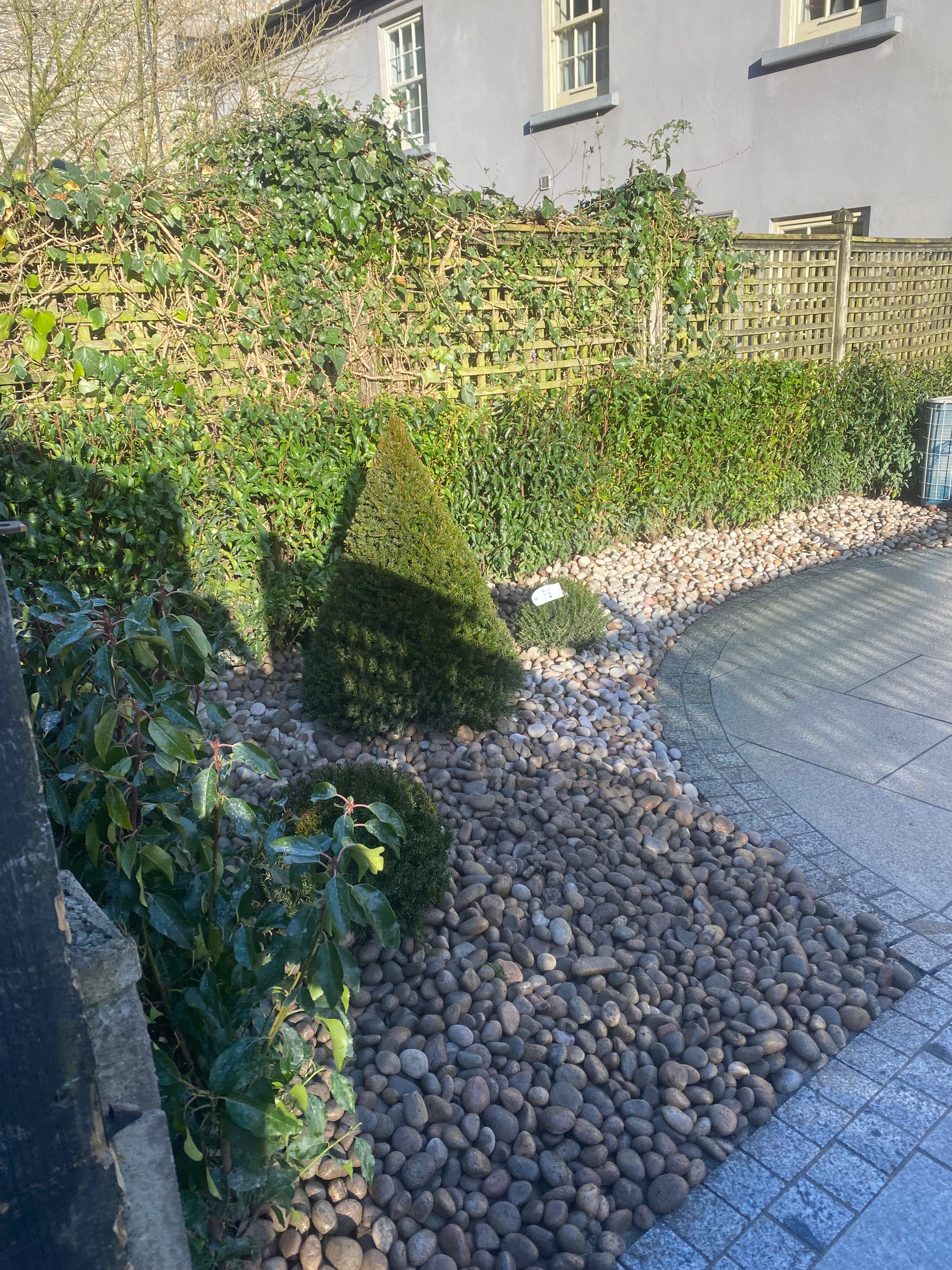 Granite patio detail showing pebbled shrub bed border in Kells, Meath